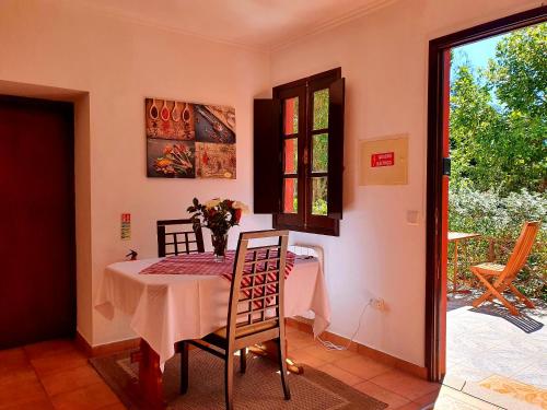 a dining room with a table and chairs and a window at One bedroom villa with furnished garden and wifi at Camacha in Camacha