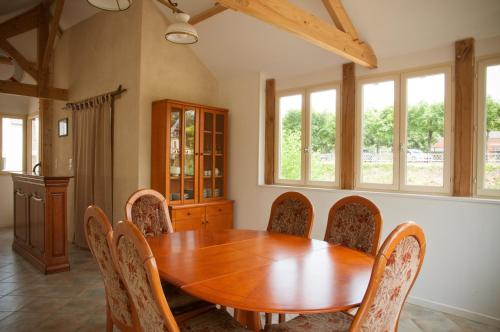 uma sala de jantar com uma mesa de madeira e cadeiras em Gîte des Grands Moulins de Baugé em Baugé