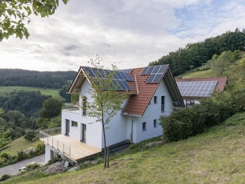 a house with solar panels on the roof at Ferienwohnungen am Dollenberg in Bad Peterstal-Griesbach