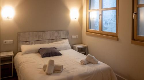 Un dormitorio con una cama con dos toallas encima. en Toro 2, 2º en la misma Plaza Mayor de Salamanca, en Salamanca