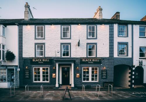 een zwart-wit gebouw met een zwarte stier bij Black Bull Hotel in Kirkby Stephen