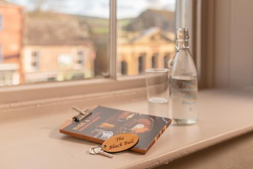 Un par de llaves y un libro en el alféizar de la ventana. en Black Bull Hotel, en Kirkby Stephen