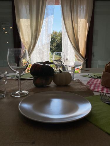 a plate on a table with two wine glasses at La Selce Farmhouse in Bagnaria Arsa