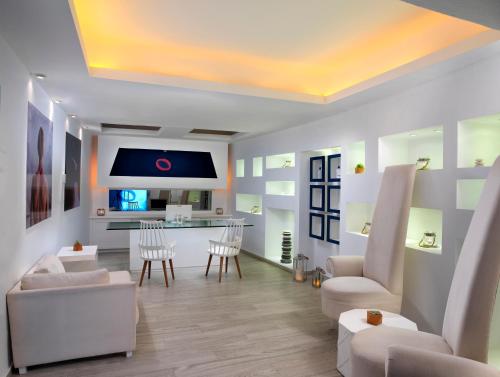 a living room with white furniture and a kitchen at ME Cabo by Meliá in Cabo San Lucas