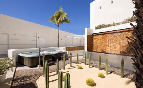 a patio with a hot tub and cactuses at ME Cabo by Meliá in Cabo San Lucas