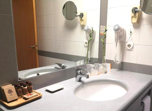 a bathroom with a sink and a mirror at Riviera Hotel in Carcavelos