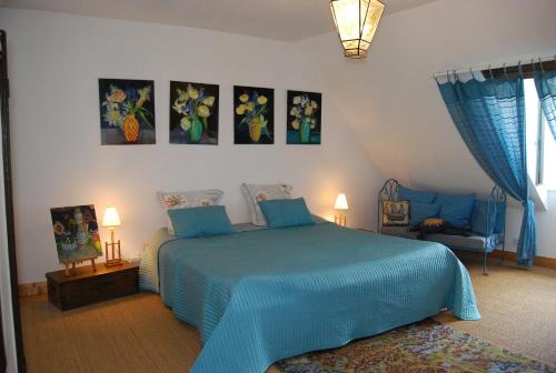 um quarto com uma cama azul e uma cadeira em B&B La Closeraie em Vouvray