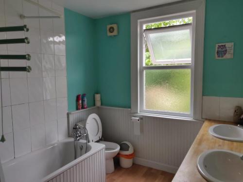 a bathroom with a tub and a toilet and a window at The Albany House Vacation Home in Bath