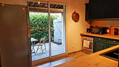 uma cozinha com uma porta de vidro deslizante para um pátio em L'agréable maison du Verdon em Gréoux-les-Bains