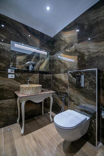 a bathroom with a toilet and a sink at Legacy Boutique Hotel in Korçë