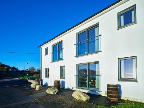 a white building with rocks in front of it at White Watch in Lochaline