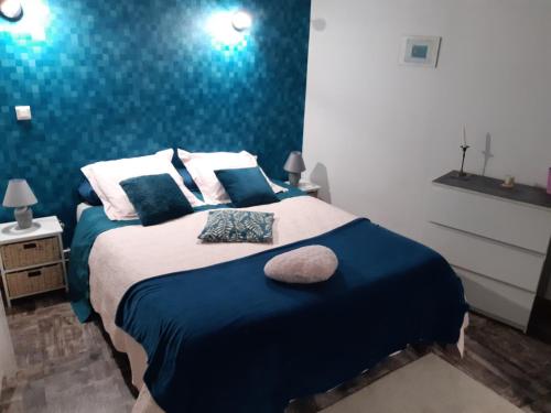 1 dormitorio con 1 cama con pared azul en ferme des champs, en Vrécourt