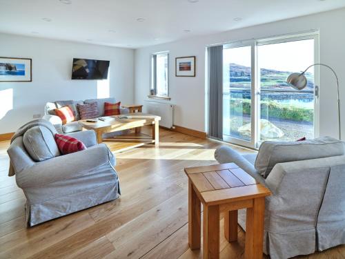 a living room with two chairs and a table at White Watch in Lochaline