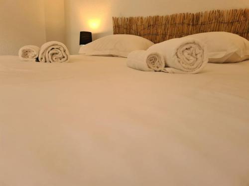 un lit avec des couvertures blanches et des oreillers dessus dans l'établissement Joli T2 lumineux et cosy au centre d'Annecy, à Annecy