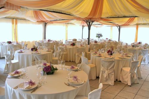 een feestzaal met tafels en stoelen met witte tafelkleden bij Albergo Miniere in Traversella