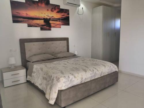 a bedroom with a bed and a painting on the wall at Résidence Sophia in Fatick