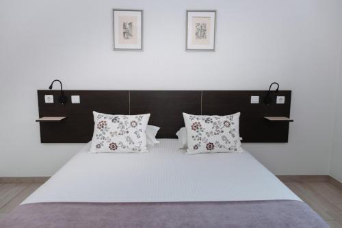 sypialnia z dużym białym łóżkiem z poduszkami w obiekcie HI Viseu - Pousada de Juventude w mieście Viseu