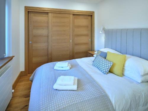 1 dormitorio con 1 cama con toallas en Red Watch Apartment, en Oban