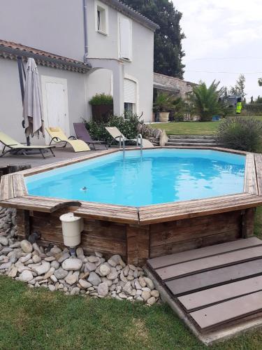 une grande piscine entourée d'une terrasse en bois. dans l'établissement Villa accueillante à Colonzelle avec piscine privée, à Colonzelle