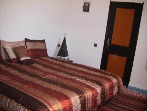 a bedroom with a bed with a colorful comforter at Atlas Resorts in Aït Ourir