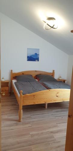 a bedroom with a wooden bed in a room at Ferienwohnanlage Brünnstein Wohnung 54 in Oberaudorf