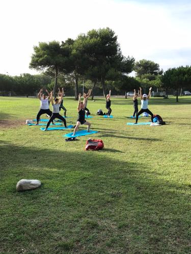 a group of people doing yoga in a park at GetWet SurfCamp II in Costa da Caparica