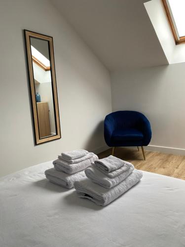 a pile of towels sitting on a bed with a mirror at Sacré cœur - Duplex avec balcon - 4 pers in Cholet