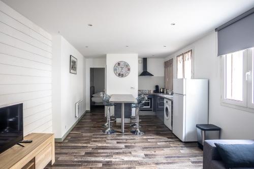 a kitchen with a table and a refrigerator at Le Saint Louis in Périgueux