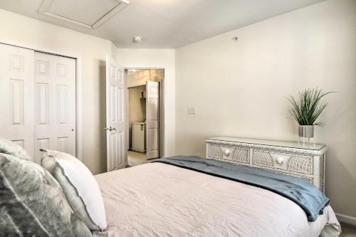a bedroom with a bed and a dresser with a plant on it at 2 Mi to Bethany Beach Condo with Deck and Pool Access in Ocean View