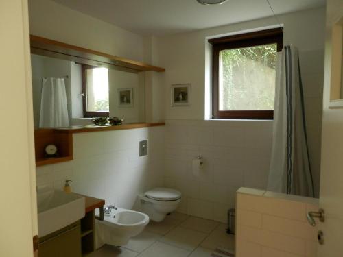 La salle de bains est pourvue de toilettes, d'un lavabo et d'une fenêtre. dans l'établissement Csiki Apartman, à Budaörs