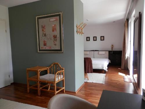 une chambre avec un lit et une chaise dans l'établissement Csiki Apartman, à Budaörs