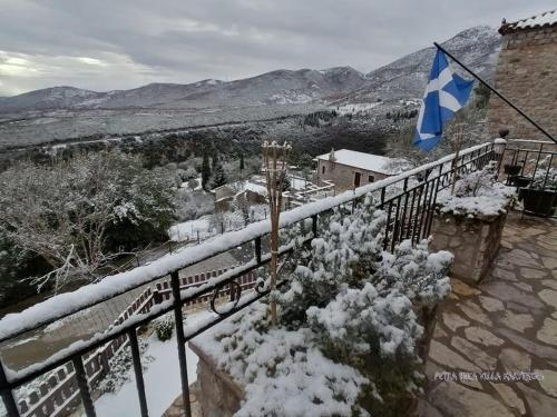 a balcony with a flag and snow on the railing at Petra Thea Villa Karitaina in Karítaina