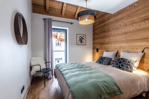 - une chambre avec un lit et un mur en bois dans l'établissement Barmes des Mossettes 4, à Morzine