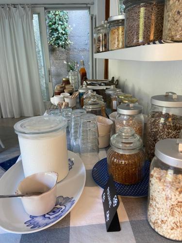 a table filled with jars and a plate with a cup of coffee at Valle dei Mulini B&B in Marciana