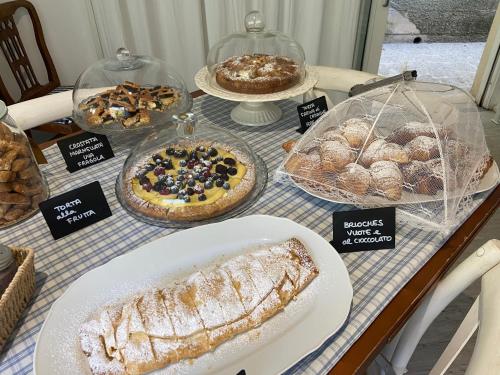 a table with different types of pastries and pies at Valle dei Mulini B&B in Marciana