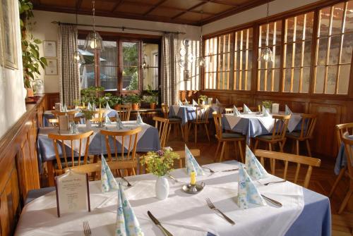 a dining room with tables and chairs with blue table cloth at Landgasthof Haueis in Marktleugast
