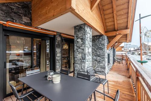 une table et des chaises sur le balcon d'une maison dans l'établissement Barmes des Mossettes 4, à Morzine