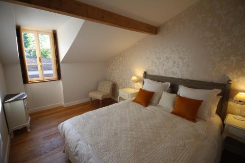 - une chambre avec un lit doté d'oreillers orange et une fenêtre dans l'établissement Forge Saint Martin, à Mary-sur-Marne