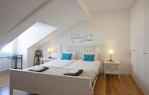 a bedroom with a large white bed with blue pillows at Casa das Andorinhas in Lisbon