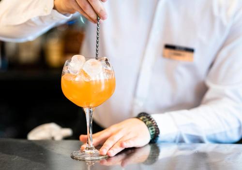 a bartender preparing a drink in a cocktail glass at Dukes Head Hotel Kings Lynn in Kings Lynn