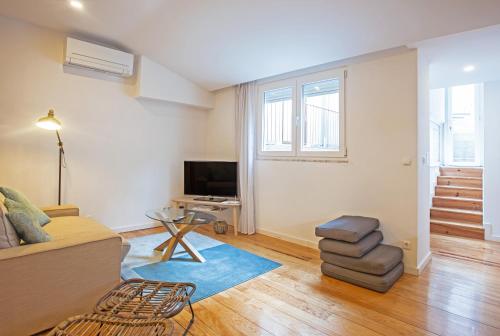 a living room with a couch and a tv at Casa das Andorinhas in Lisbon