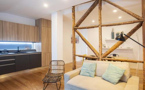 a living room with a couch and a kitchen at Casa das Andorinhas in Lisbon