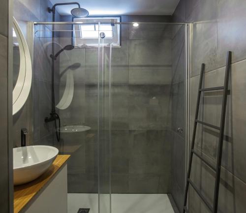 a bathroom with a glass shower and a sink at Casa das Andorinhas in Lisbon