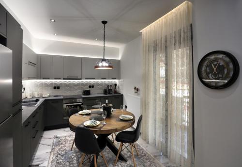 a kitchen with a wooden table and chairs at LA Larissa Luxury Apartments Kreousa in Larisa