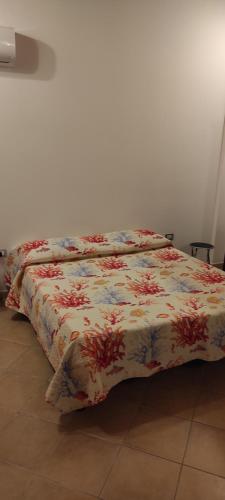 un letto con piumone floreale in camera di Casa vacanze di Rossano a Carbonia