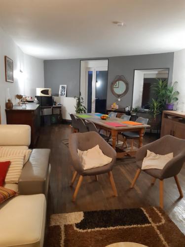 un salon avec un canapé, une table et des chaises dans l'établissement ferme des champs, à Vrécourt