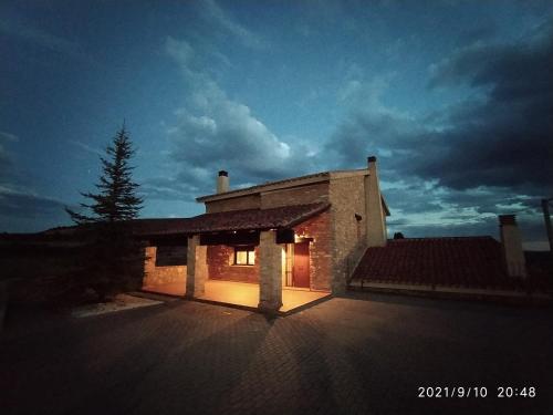 a house with its lights on in front of it at Puerta del Maestrazgo in Monteagudo del Castillo