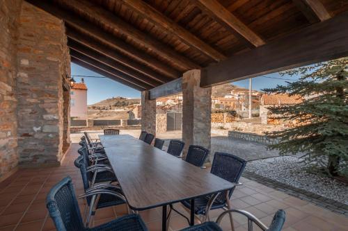 a large wooden table and chairs on a patio at Puerta del Maestrazgo in Monteagudo del Castillo