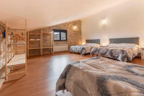 a bedroom with three beds and a staircase at Puerta del Maestrazgo in Monteagudo del Castillo