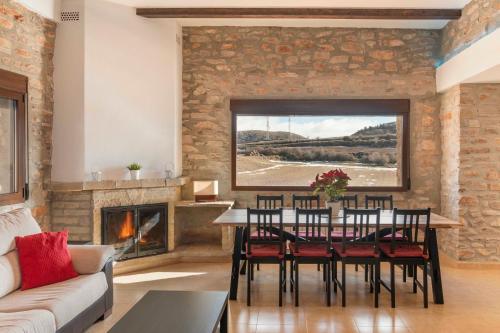 a living room with a table and chairs and a fireplace at Puerta del Maestrazgo in Monteagudo del Castillo